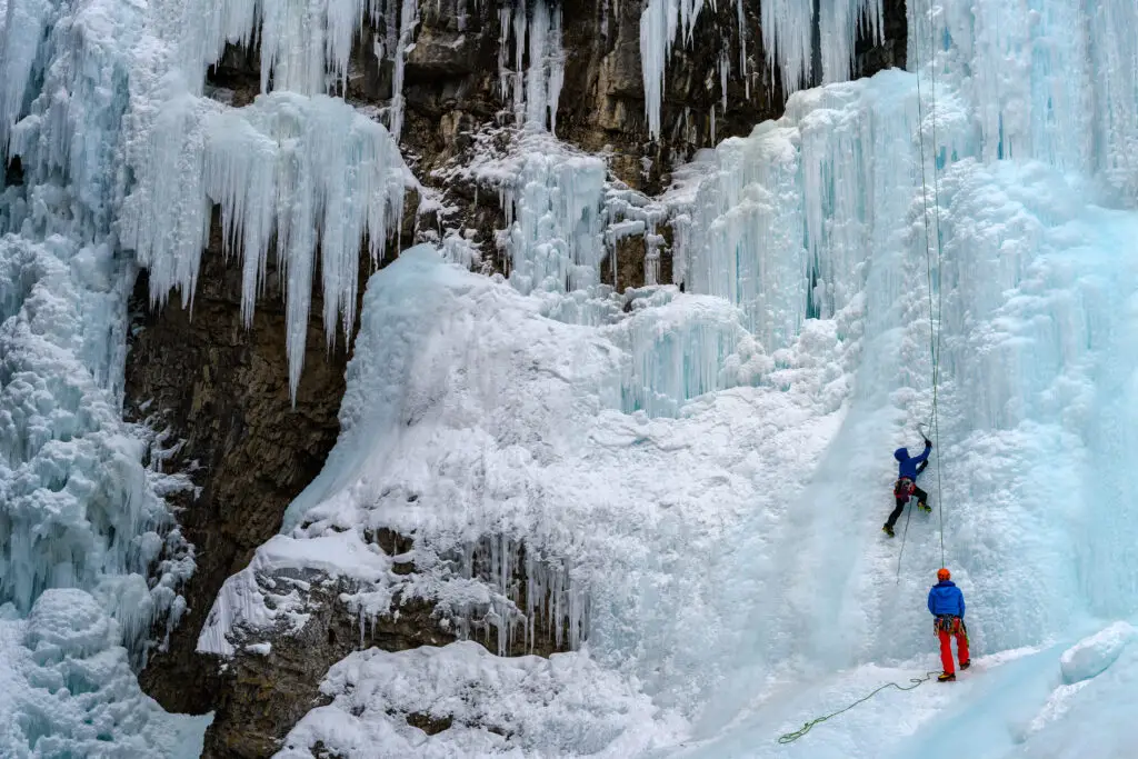 Ice climber on the frozen Upper Falls of the Johnston Creek during winter, Johnston Canyon, Banff National Park, Canadian Rocky Mountains, Alberta, Canada.