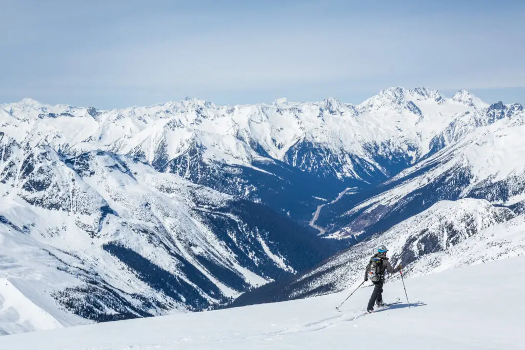 Skier hiking across to Youngs Peak overlooking the Asulkan Valley and Highway 1 through Rogers Pass in Glacier National Park, Canada.