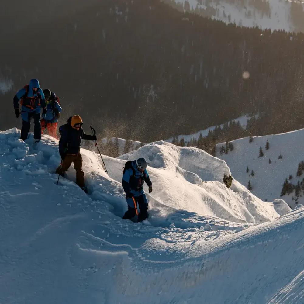 group of skiers in bright ski suits are walking at snow-covered mountain trail. Ski touring and freeride concept